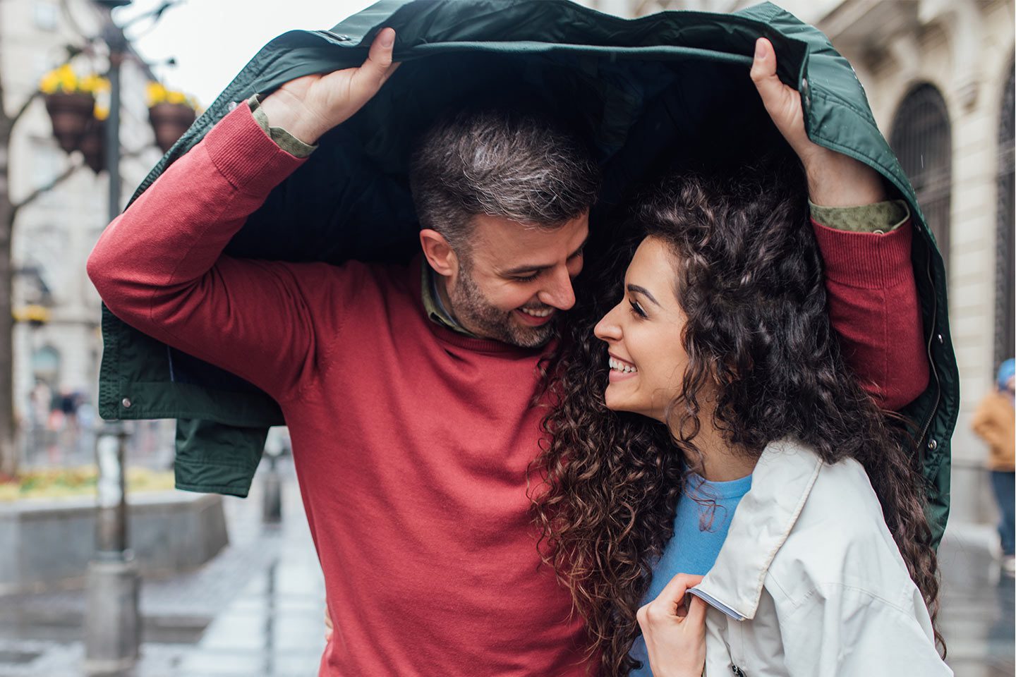 Husband shielding his wife from the rain