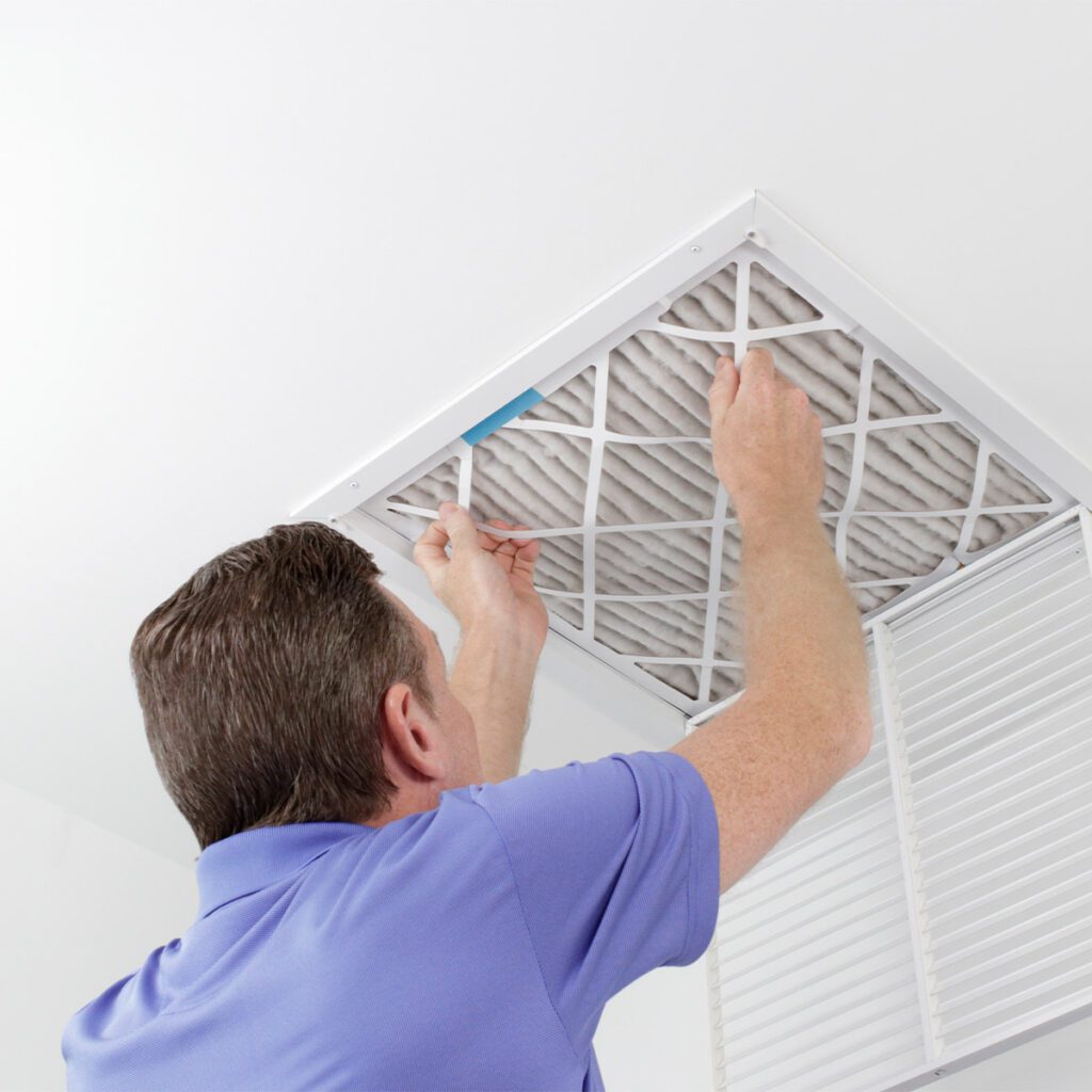 man replacing ceiling air filter