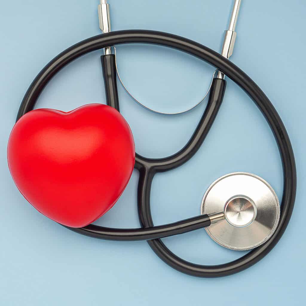 rapid cardiac care | plastic red heart with stethoscope in blue background