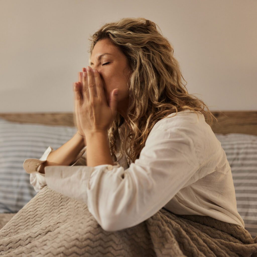 woman having nighttime allergies in bedroom
