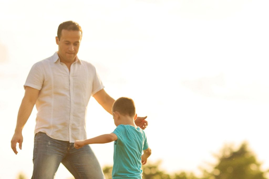 dad playing outdoors with son