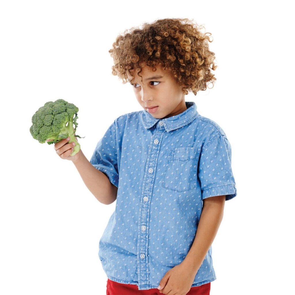 little boy with a broccoli floret