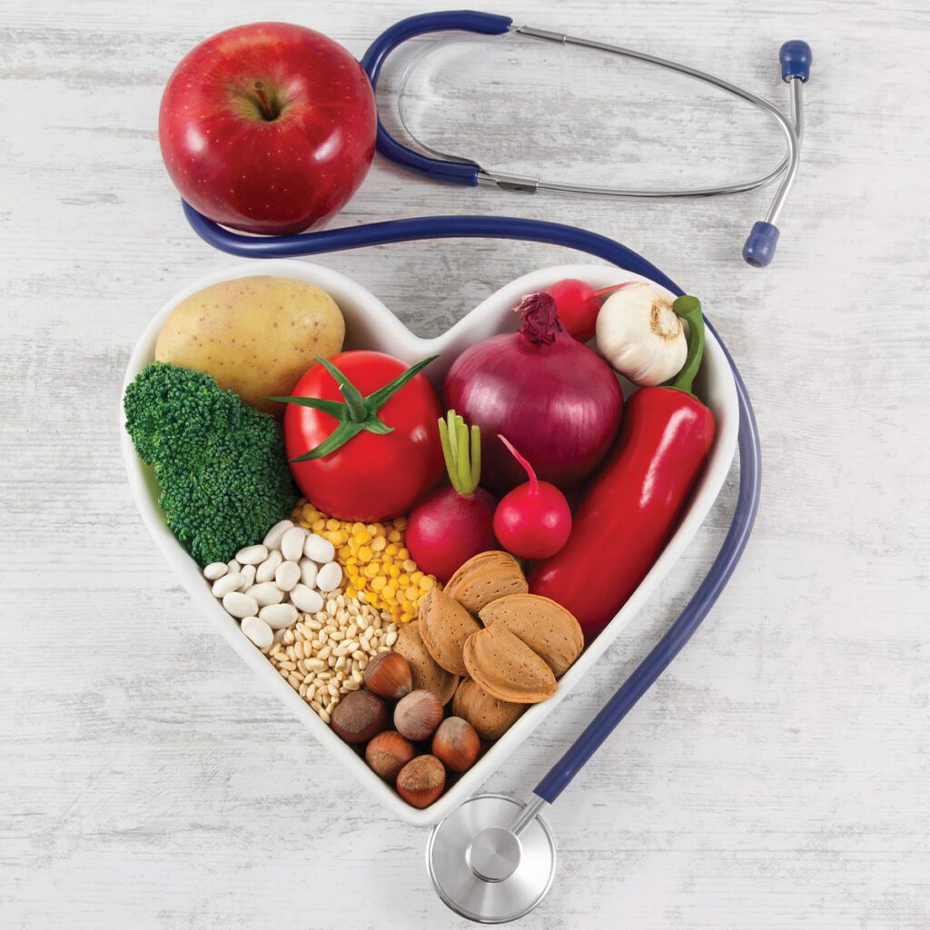 heart-shaped bowl full of vegetables with a stethoscope next to it