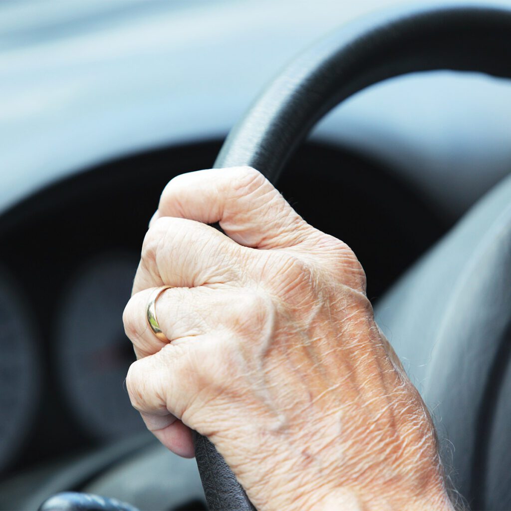 elder woman's hand on steering wheel