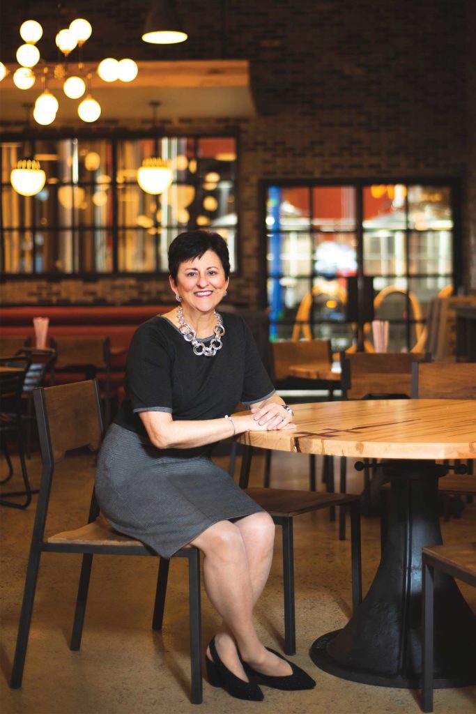 Paula Palmer sitting at table at market south