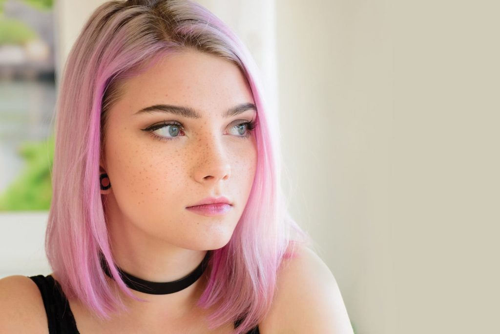 teen girl with pink hair and a ear gage piercing