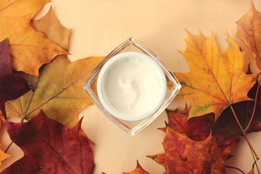 container of moisturizer on a background with leaves