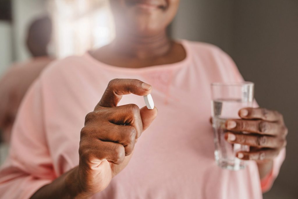 woman taking a hormone pill to combat the effects of menopause