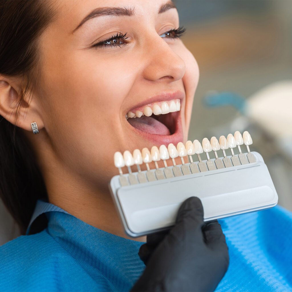 woman holding a row of artificial teeth