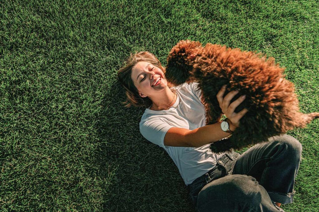 Woman holding her dog after learning the Benefits of Pets.