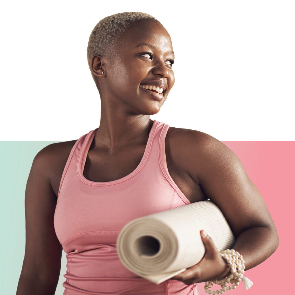 Smiling Woman holding yoga mat while looking back