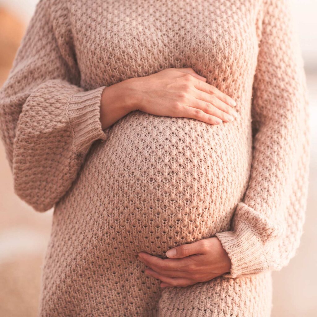 Pregnant woman holding her stomach indicating pregnancy complication