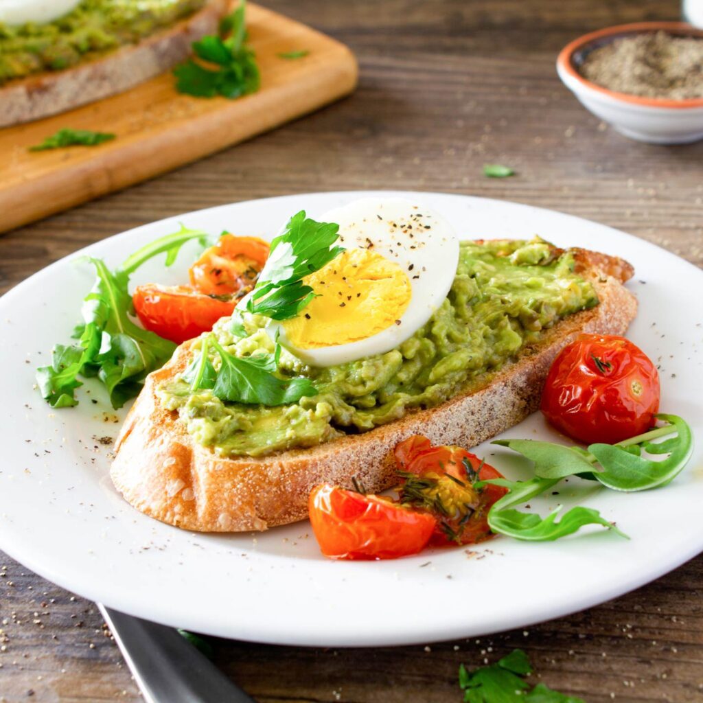 Avocado toast with an egg and tomatoes for the perfect breakfast.
