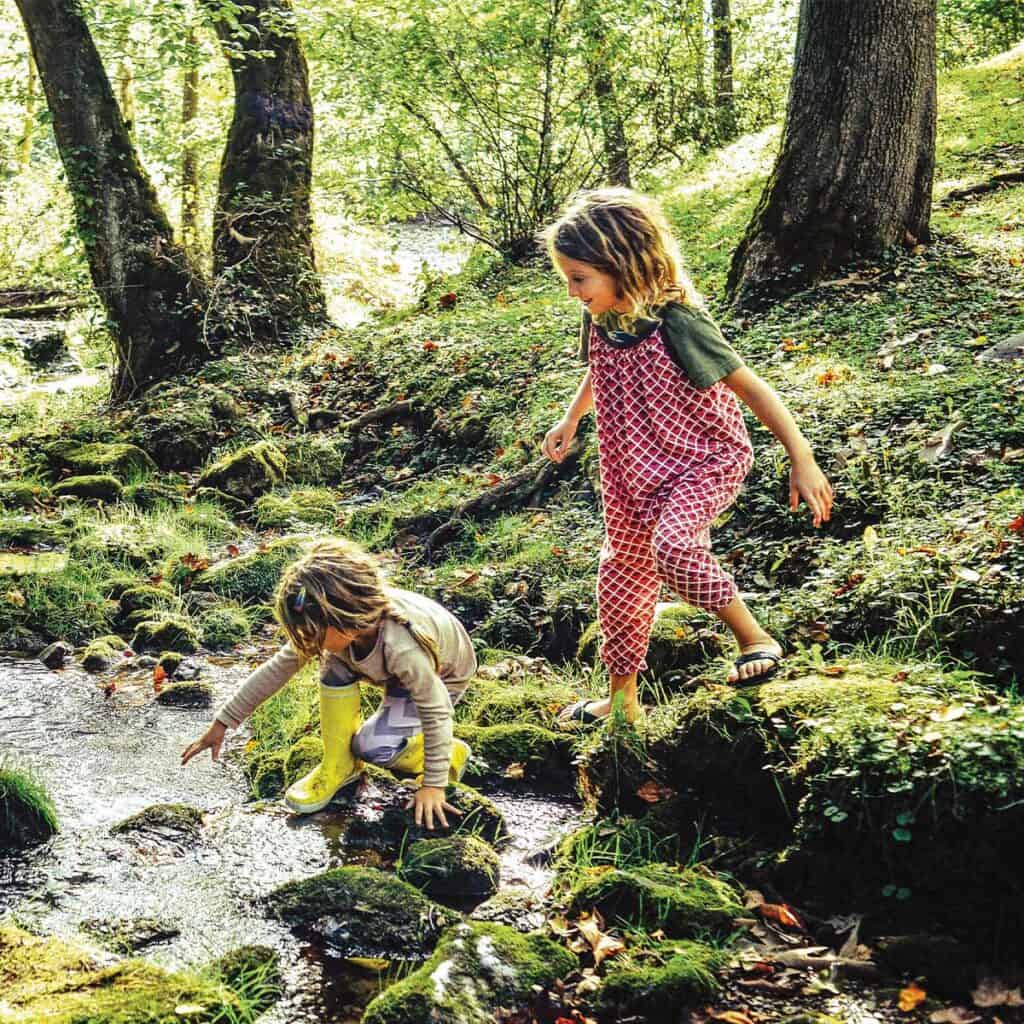 two kids playing in a creek