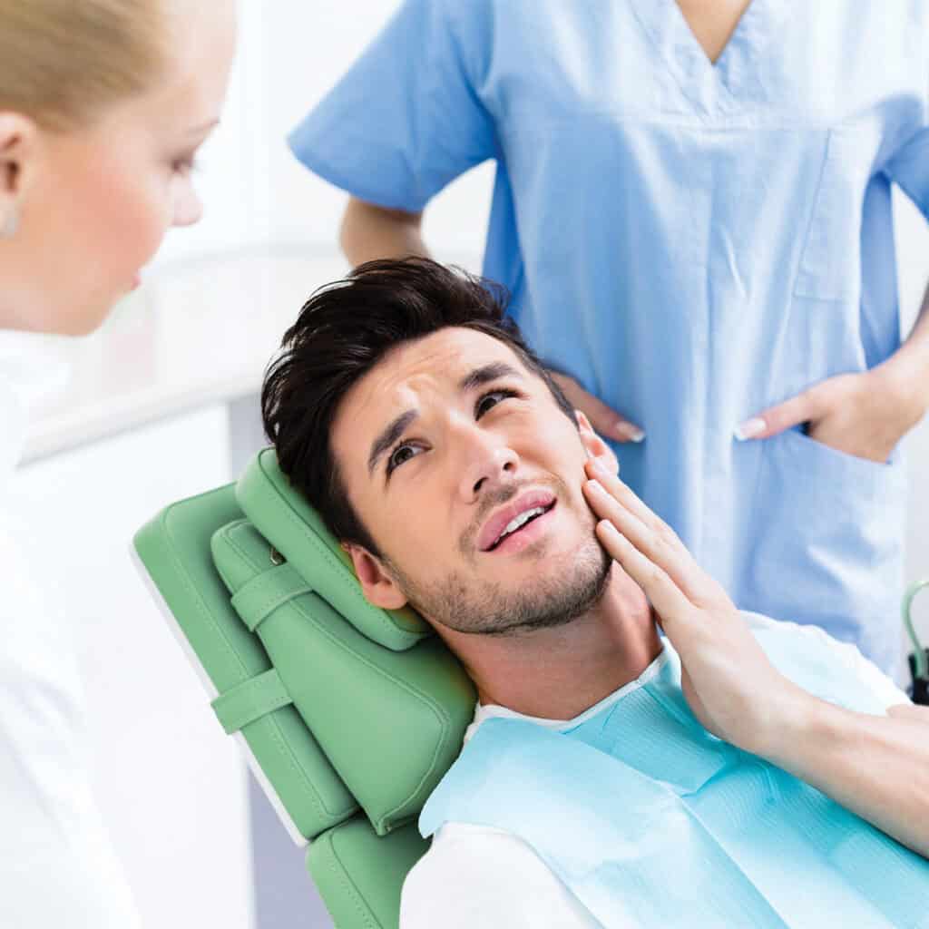 patient complaining about tooth pain to dentist