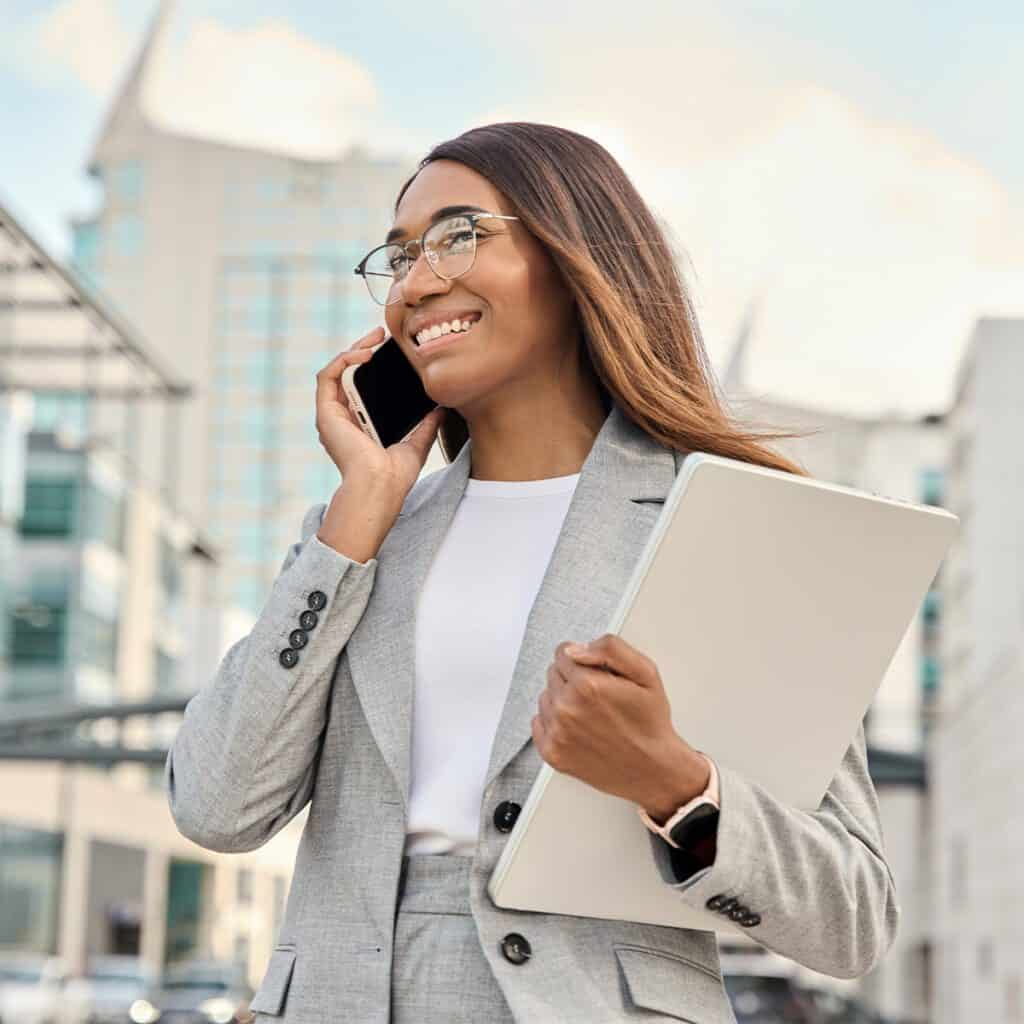 smiling business woman taking call outside