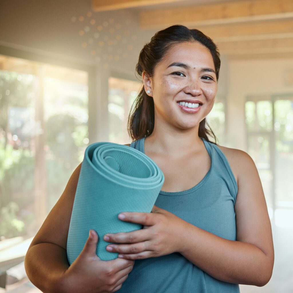 woman holding a yoga mat